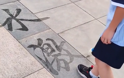 河南：大家风范！小男孩广场上写毛笔字
